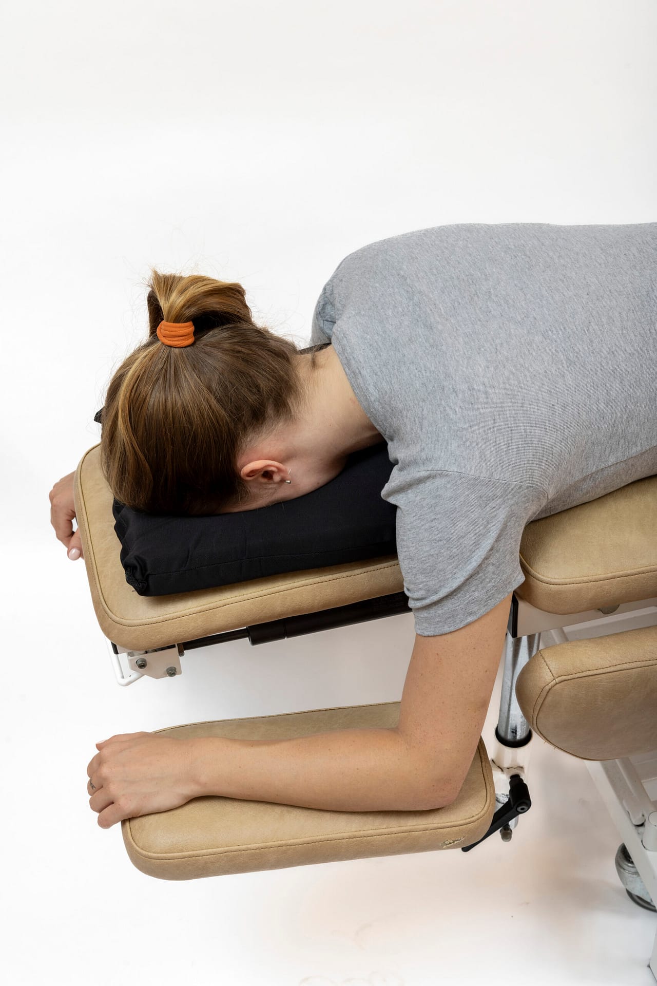 Patient using face cushion on treatment table — side view