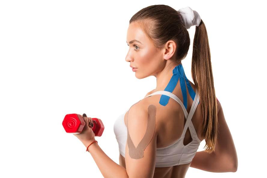 Athlete with blue and beige kinesiology tape on back and shoulder during training